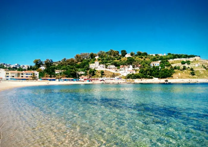 Plage de Tabarka avec eau claire et collines verdoyantes