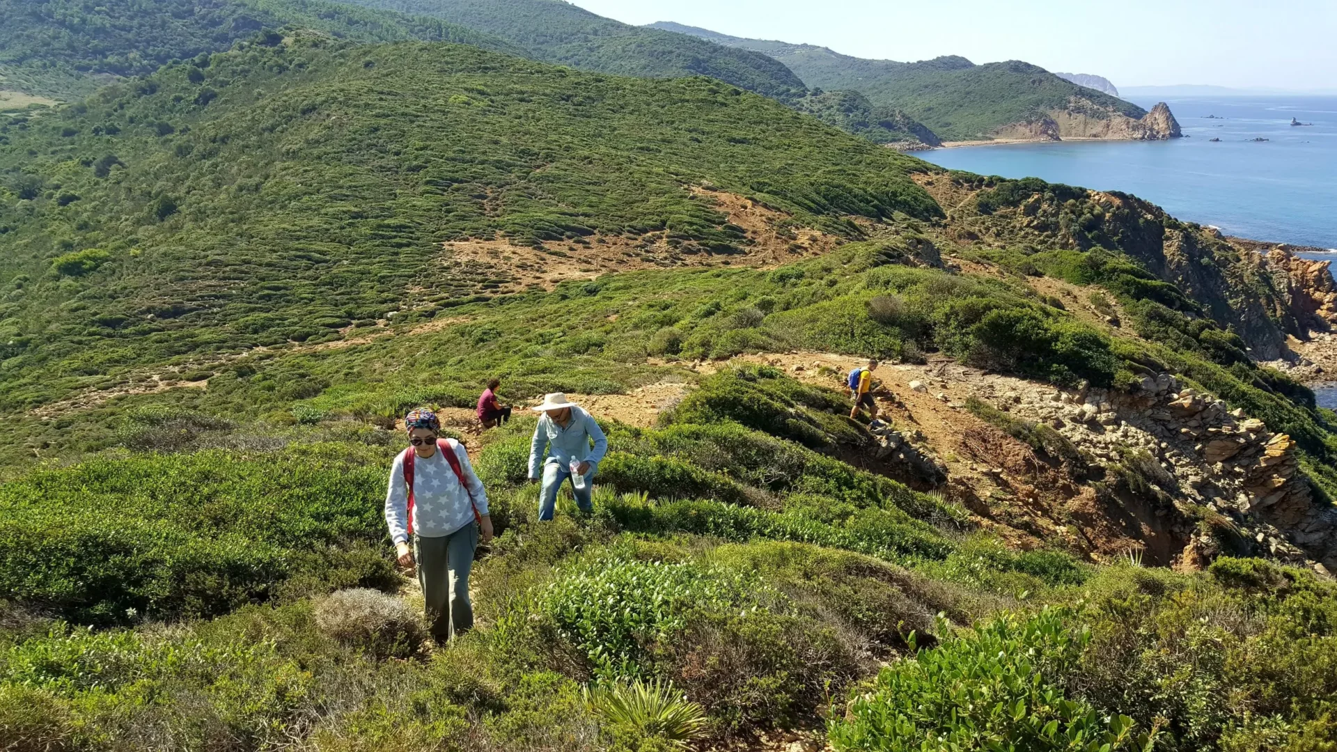 Wanderer auf einem grünen Küstenpfad in den Bergen rund um Tabarka mit Blick auf das Mittelmeer